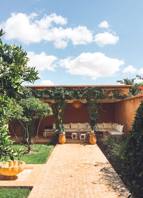 Patio couvert de la villa avec banquettes, côté jardin